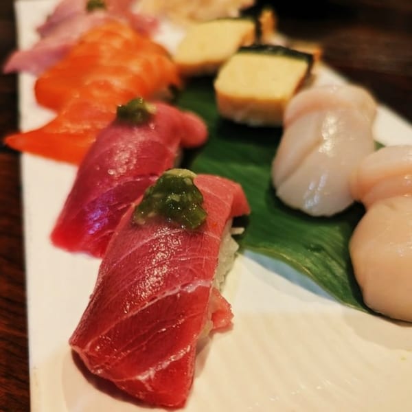 A close-up of Ginya Izakaya's fresh sushi and sashimi platter with various fish and scallops.